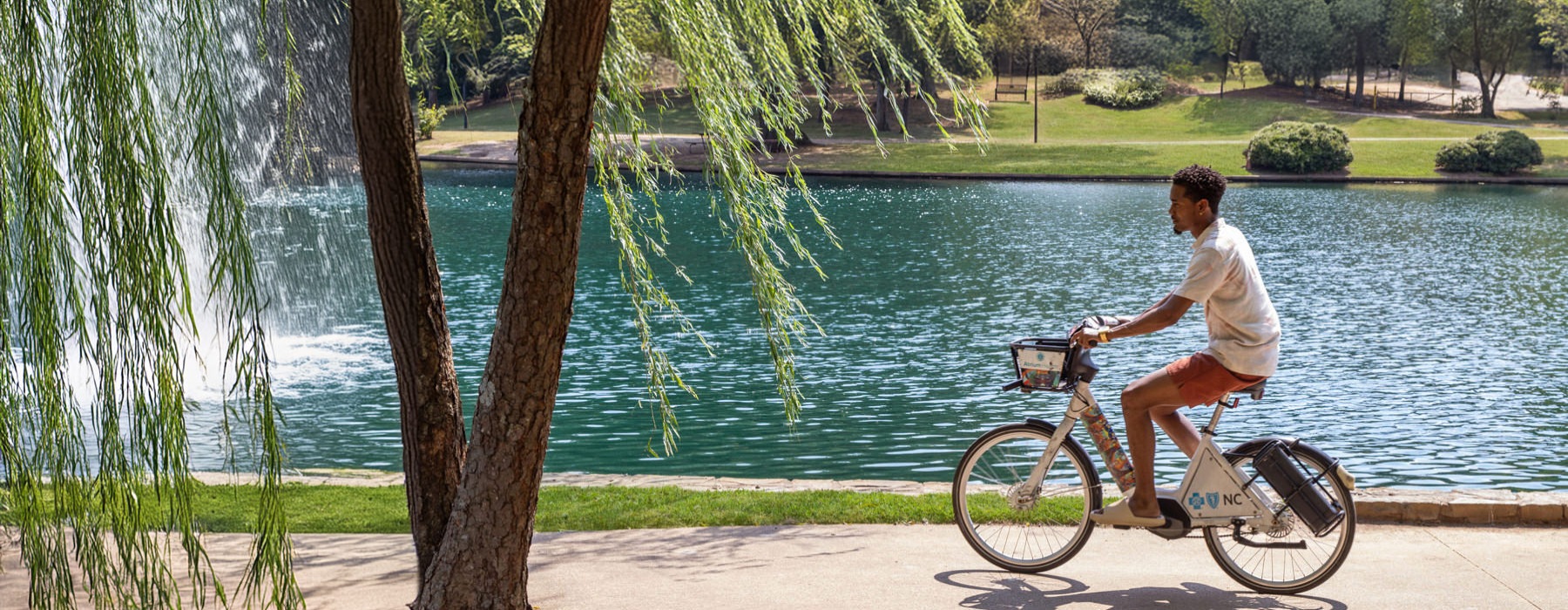 a man cycling on a sidewalk